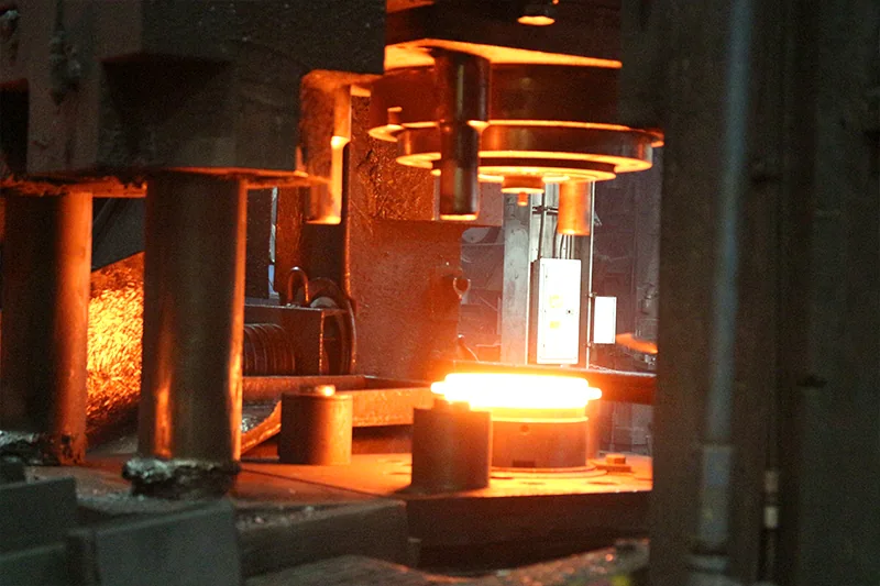 Hot forged component in a die